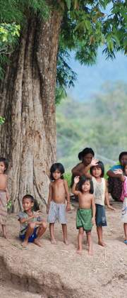 Zwaaiende kinderen langs de oever van de Mekong, Laos